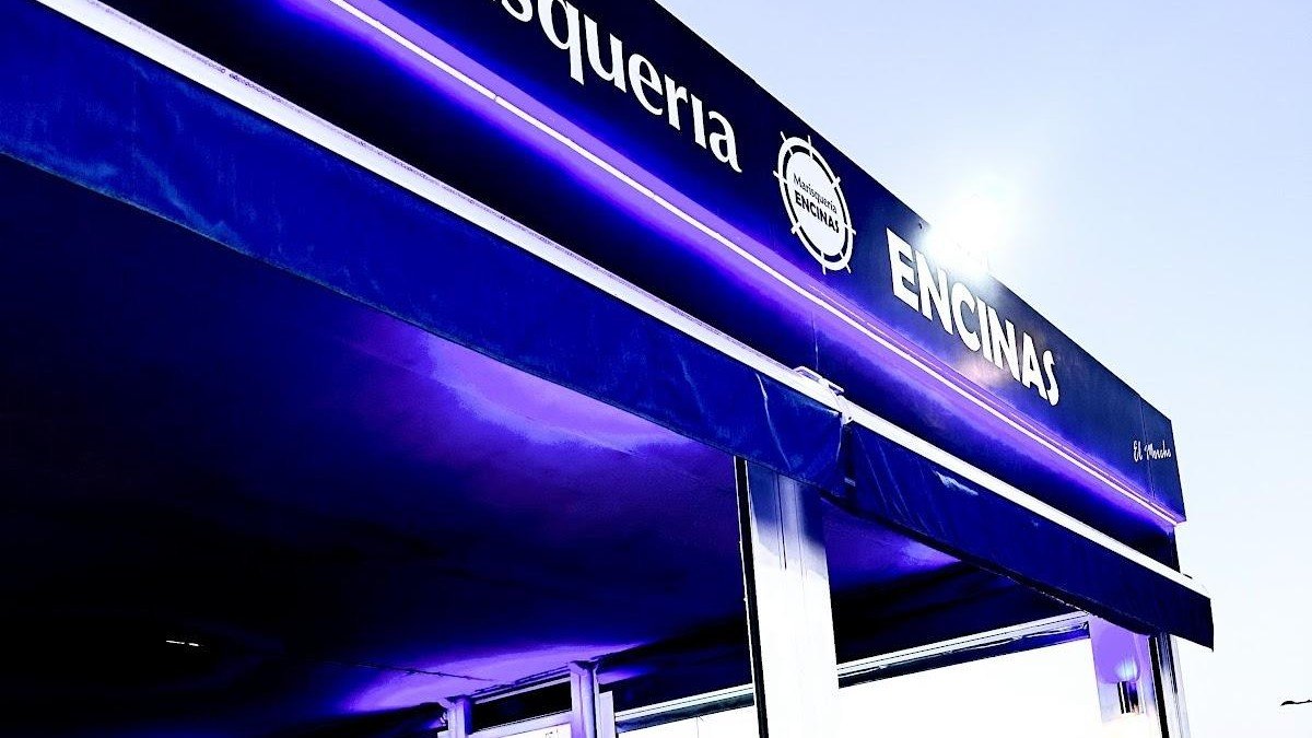 Toldo azul de Marisquería Encinas con el nombre en blanco sobre la terraza